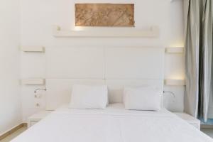 a bedroom with a white bed with two pillows at Costa Luvi Hotel Bodrum - All Inclusive in Gümbet