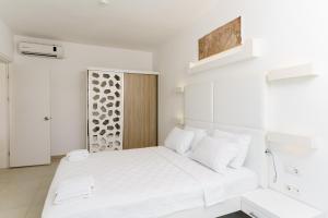 a white bedroom with a large white bed with white pillows at Costa Luvi Hotel Bodrum - All Inclusive in Gümbet
