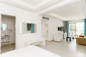 a white room with a white bed and a living room at Costa Luvi Hotel Bodrum - All Inclusive in Gümbet