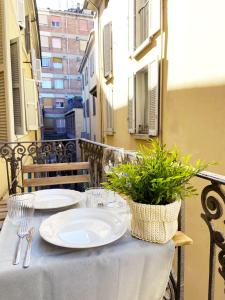 une table avec des assiettes et de l'argenterie sur un balcon dans l'établissement Wild Apartment, à Parme
