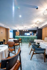 a restaurant with tables and chairs and a bar at Ador Hotel in Pristina
