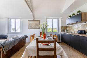 uma cozinha e sala de estar com uma mesa e um sofá em Jolie Brise em Pléneuf-Val-André