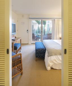 um quarto com uma cama, uma secretária e uma televisão em Pavilion Hotel em Avalon