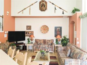 a living room with couches and a flat screen tv at 5 Bed 8002 in Kissimmee