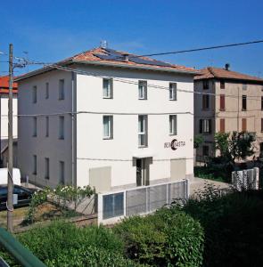 un edificio blanco con una valla delante en Bed & Basta, en Reggio Emilia