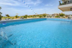 a large swimming pool with blue water at סוויטת עמית- נופש משפחתי 5 דקות הליכה מהים in Nahariyya