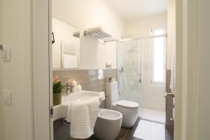 bagno bianco con servizi igienici e lavandino di Bed & Basta a Reggio Emilia