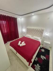 a bedroom with a bed with two slippers on it at Queen Kodre Apartments in Ulcinj