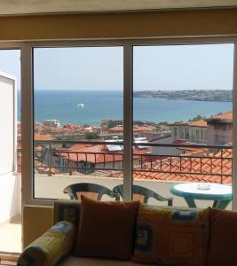a living room with a couch and a view of the ocean at Guest House Polikseni in Sozopol