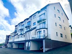 a white building with balconies on the side of it at Lovely New 2 Bedroom Condo with Stunning Seaviews in Penmaen-mawr
