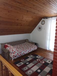 a bed in a room with a wooden ceiling at Vikendica Ivana in Divčibare