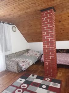 a living room with a couch and a brick pillar at Vikendica Ivana in Divčibare