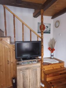 a flat screen tv sitting on top of a wooden stand at Vikendica Ivana in Divčibare