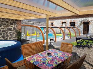 a patio with a table and chairs and a pool at Duplex Swimming Cats in Saint-Hilaire-sur-Helpe