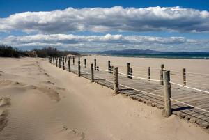 a beach with a wooden fence in the sand at Hostal Restaurant Paca in Riumar