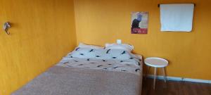 sypialnia z łóżkiem w żółtej ścianie w obiekcie Cottage Halle-Hunneberg w mieście Vargön