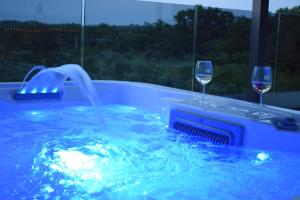 dos copas de vino en una bañera de hidromasaje con una fuente en Villa Indigo, en Umag