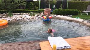 zwei Kinder spielen in einem Pool im Hinterhof in der Unterkunft Generations Holiday Garden Flats in Attendorn