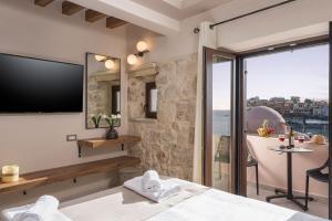 a hotel room with a large tv and a balcony at La vista de Pablo in Chania Town