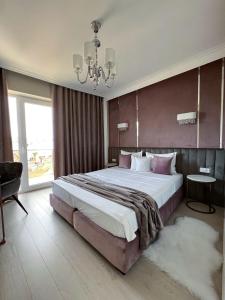 a large bedroom with a large bed and a chandelier at NOVAPART AKAASIA in Cluj-Napoca