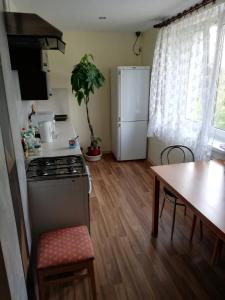 kuchnia z kuchenką, lodówką i stołem w obiekcie Kwatery pracownicze Łódź w Łodzi