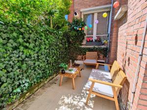 patio ze stołem i krzesłami obok ściany z cegły w obiekcie Le Rainbow - Grand studio avec terrasse w mieście Dunkierka