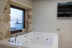 łazienka z dużą białą wanną z oknem w obiekcie La vista de Pablo w Chanii