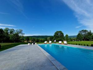 a swimming pool with lounge chairs in a yard at Villa Eda in Bihać