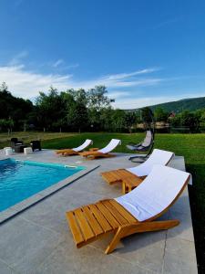 a group of lounge chairs and a swimming pool at Villa Eda in Bihać