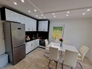 a kitchen with a white table and white chairs at Villa Eda in Bihać