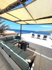 a living room with a couch and an umbrella at Villa Michael in St Paul's Bay