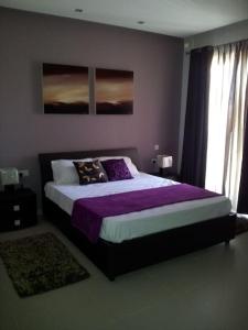 een slaapkamer met een groot bed met paarse lakens bij Sunny 2 bedroom, 2 bathrooms, seaside apt. in Sliema