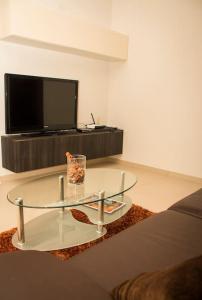 een woonkamer met een glazen salontafel en een televisie bij Sunny 2 bedroom, 2 bathrooms, seaside apt. in Sliema