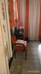 uma sala de estar com uma cadeira e uma mesa em petit chez soi dans mon petit chez moi em Biganos