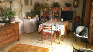 une cuisine avec une table et un chien assis sur une chaise dans l'établissement petit chez soi dans mon petit chez moi, à Biganos
