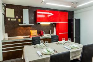 a kitchen with a table with chairs and red cabinets at Vila Hrastovi in Sutomore