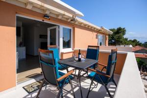 a patio with a table and chairs on a balcony at Apartments Stermasi in Saplunara