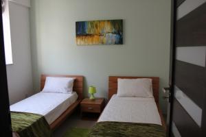 een slaapkamer met 2 bedden en een schilderij aan de muur bij Sunny 2 bedroom, 2 bathrooms, seaside apt. in Sliema