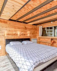 グリュイッサンにあるDuplex Climatisé 65m2 refait à neufの木製の天井の客室のベッド1台分です。