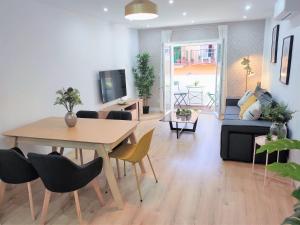 a living room with a table and chairs and a couch at Malagueta Beach & Muelle1 & Centre con Parking Privado in Málaga