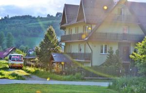 una furgoneta estacionada frente a una casa grande en Pokoje gościnne u Bożenki, en Krościenko nad Dunajcem