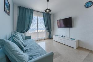 un soggiorno con divano blu e TV di Santiago Astalavista Sea View a Puerto de Santiago