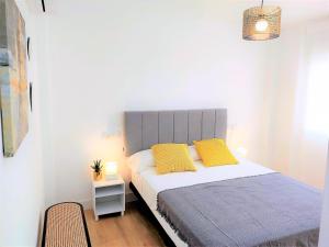 um quarto com uma cama com duas almofadas amarelas em Malagueta Beach & Muelle1 & Centre con Parking Privado em Málaga