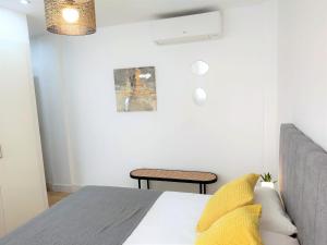 um quarto branco com uma cama e uma cadeira em Malagueta Beach & Muelle1 & Centre con Parking Privado em Málaga
