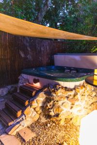 a hot tub sitting next to a wooden fence at Khashamongo B & B in Somerset West