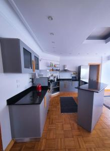 a large kitchen with black counter tops and wooden floors at Madina Hostel in Cairo