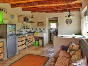 a kitchen with a couch and a counter in a room at Die Hoenderhok and Die Plaashuisie in Swellendam