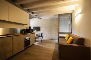eine Küche und ein Wohnzimmer mit Sofa und Tisch in der Unterkunft Ambra suite in Mantua