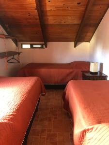 2 camas en una habitación con techos de madera en El Mirador, en Punta del Diablo