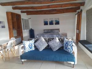 een slaapkamer met een bed met blauwe en witte kussens bij Die Hoenderhok and Die Plaashuisie in Swellendam